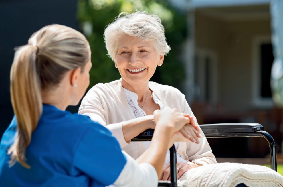 Caregiver attentively speaking with an older woman